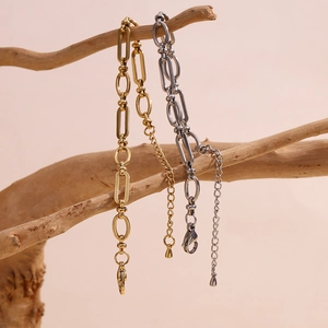 Minimalist 14K gold and silver stainless steel paperclip chain bracelets on wood branch