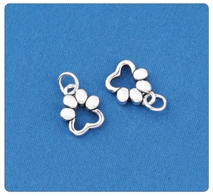 Macro detail of silver S925 pet paw charms showing the glossy metal texture and DIY ring