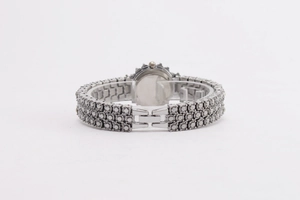 Detail eines luxuriösen silbernen Uhrenarmbands mit drei Reihen funkelnder Kristalle