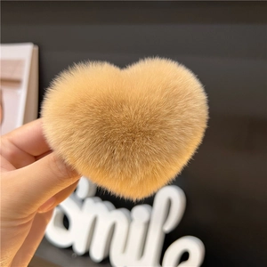 Detailed close-up of a heart-shaped brown plush hair clip with soft faux fur texture