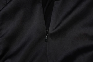 Detail view of a smooth black satin back featuring a high-quality invisible zipper closure