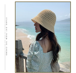 Détail d'un chapeau cloche en paille tissé à la main avec motif ajouré et robe fleurie
