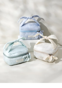Floral jacquard cosmetic bags with bow handles in blue, green, and cream white colors