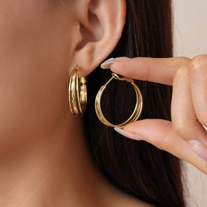 Close-up of gold layered hoop earrings featuring faceted diamond-cut metal texture