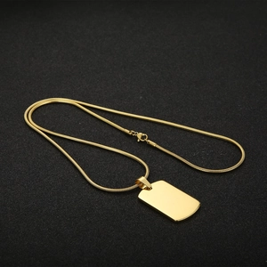Golden stainless steel military dog tag necklace with a polished mirror finish on dark background