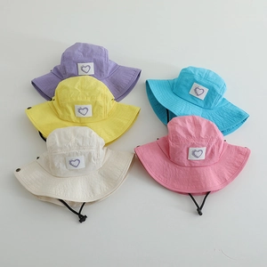 Detail shot of five colorful kids bucket hats with adjustable drawstrings and heart patches