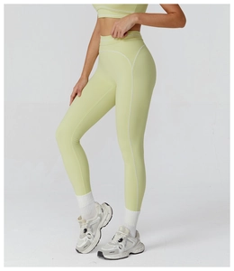 Close-up of contrast white stitching on high-waist light green yoga leggings and tank top