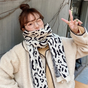 Detailed knit texture of black and white leopard print scarf with wool-like jacket