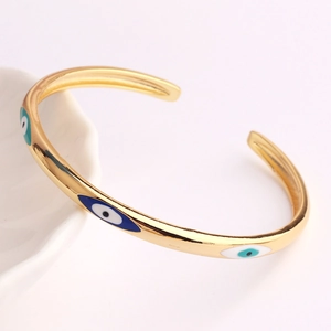 Detailansicht des goldenen C-förmigen Evil Eye Armbands mit bunten Emaille-Anhängern