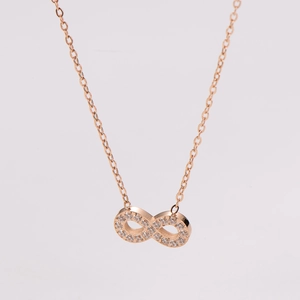 Close-up of rose gold infinity pendant necklace with shimmering cubic zirconia crystals