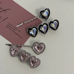 Close-up of heart-shaped rhinestone hair clips in pink and silver alloy finish