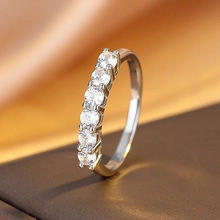 Macro shot of silver ring with seven round-cut diamonds on silk background