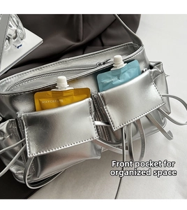 Detail view of silver pleated baguette bag with functional front pockets for small items