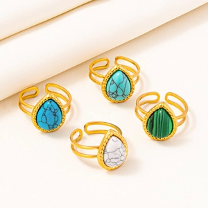 Detailed view of four adjustable gold stainless steel rings with colorful turquoise stones