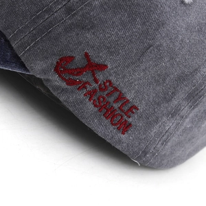 Detailed close-up of red embroidered 'STYLE FASHION' logo on grey washed cotton denim cap
