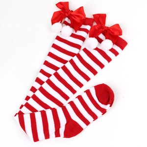 Detail of red and white striped over-knee socks with satin bow and white pom-poms
