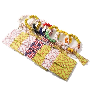 Silicone bead wristlet keychain with baseball pattern, yellow tassel, and PU leather wallet