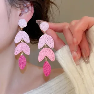 Pink bohemian raffia tassel earrings with layered leaf design for beach vacations