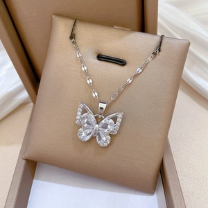 Macro shot of butterfly necklace with clear zircons on champagne silk display