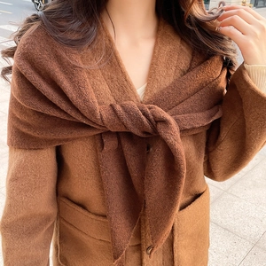 Détail d'une écharpe en laine marron montrant sa texture épaisse et son drapé élégant