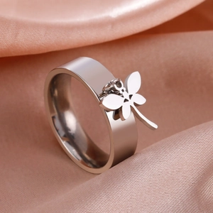Polished stainless steel band ring with a delicate dragonfly charm on pink satin