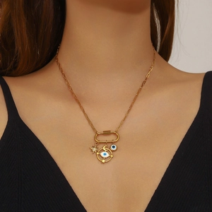 Gold layered necklace featuring star, crescent moon, and evil eye charms on a paperclip link
