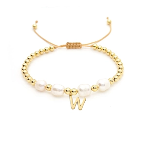 Detail of adjustable woven bracelet featuring baroque pearls and gold letter W charm