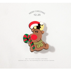 Détail macro du pin's renne de Noël avec bonnet festif et canne en sucre