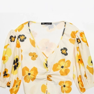 Women's V-neck puff sleeve floral crop top with ribbed texture on white background