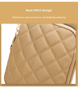 Detail of khaki quilted nylon fabric with precise stitching and gold metal zipper