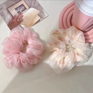 Macro view of mesh floral organza scrunchies in soft pink and cream white tones