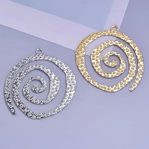 Close-up of gold and silver spiral pendants with hammered texture for DIY jewelry making