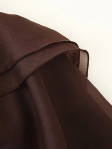 Dettaglio ravvicinato di tessuto chiffon marrone scuro con cucitura a orlo arrotolato e trama fine