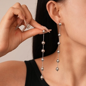 Elegant silver tassel earrings with multiple polished metallic spheres on a model