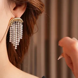 Elegant sparkling moon tassel drop earrings with crystals on a golden semi-circular base