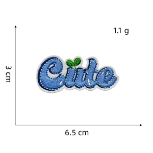 Detail of blue 'Cute' embroidered patch with green seedling and heat adhesive backing