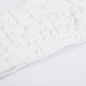 Close-up of white bubble gauze fabric texture and detailed stitching on cropped top