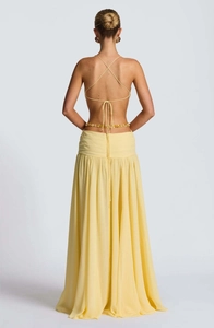 Detailed view of yellow backless maxi dress with crisscross straps and beaded waist chain