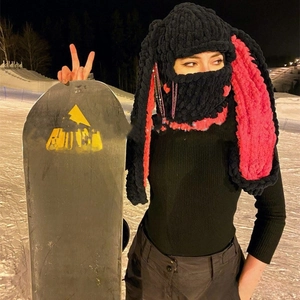 Close-up of handmade chunky knit bunny balaclava with pink rabbit ears in night ski scene