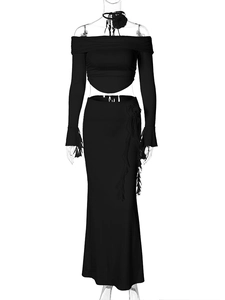 Detail of black two-piece set featuring 3D floral accents on crop top and slim skirt