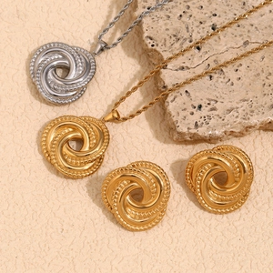 Detailed view of twisted knot necklace and stud earrings in gold and silver finish