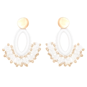 Detail of bohemian fan-shaped tassel earrings with white hand-woven beads and gold metal studs