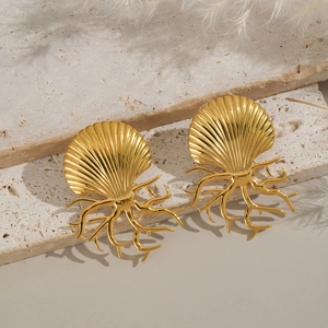 Detail of gold seashell and coral branch stud earrings on elegant marble stone base