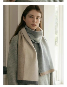 Close-up of knit scarf featuring beige, light blue and grey color-block patchwork design