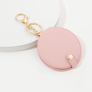 Pink PU leather round mirror keychain with golden clasp on a white display base