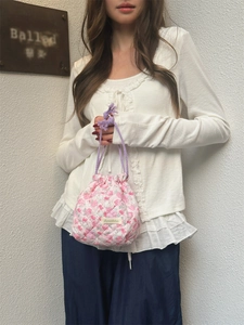 Detail of pink floral quilted drawstring bag showing textured cotton fabric and purple rope