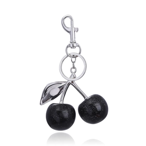Sparkly black cherry keychain with silver metal leaf and lobster clasp on white background