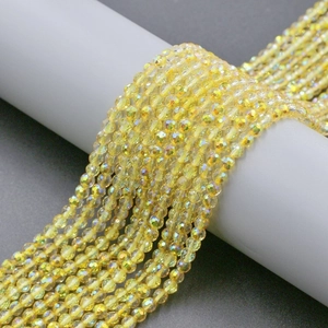 Macro shot of 4mm yellow faceted crystal glass beads with iridescent sparkle finish