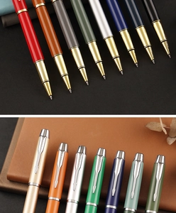 Macro detail of the metal rollerball pen tip and arrow-shaped clip on leather notebook