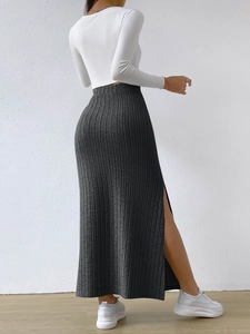 Detailed close-up of dark grey high-waisted ribbed knit midi skirt with side slit detail